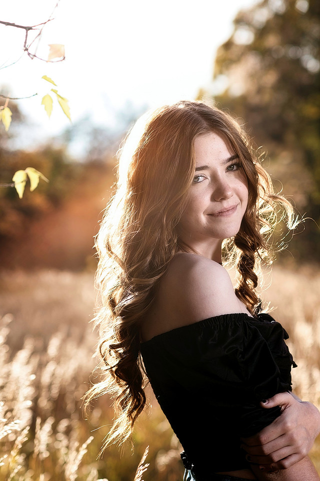 An outdoor portrait of a young woman in warm evening light