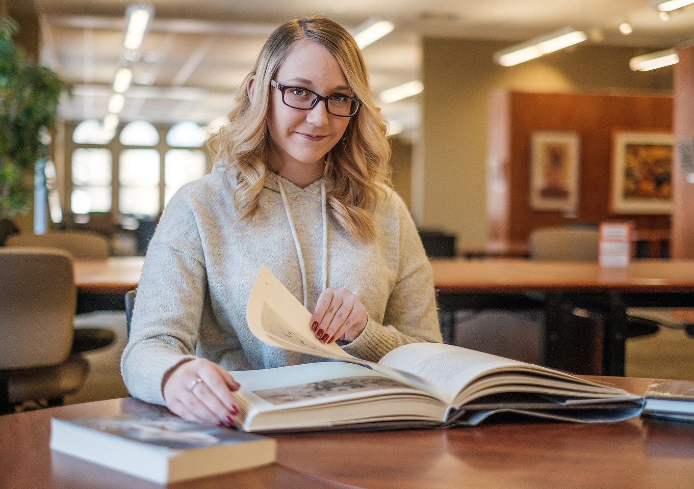 A woman looking through a book during an indoor portrait session